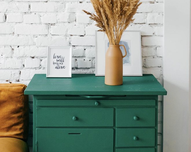 Dresser with plant and pictures set on top
